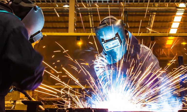 Photo of factory workers welding