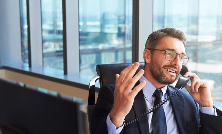 Photo of businessman talking on phone in high-rise office